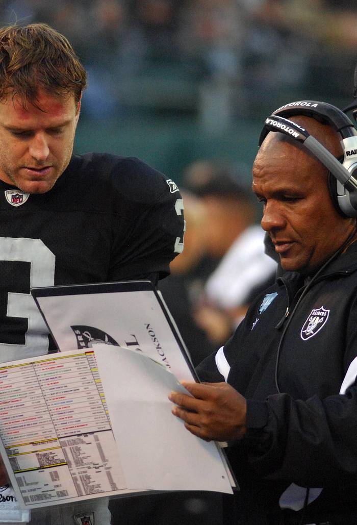 Oakland Raiders coach Hue Jackson (center) talks with quarterback Carson Palmer (3)