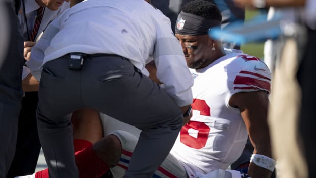 New York Giants running back Saquon Barkley (26) is examined by team staff after suffering an apparent injury during the second quarter against the Tampa Bay Buccaneers at Raymond James Stadium.