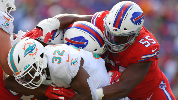 Oct 20, 2019; Orchard Park, NY, USA; Miami Dolphins running back Kenyan Drake (32) runs with the ball as Buffalo Bills defensive end Jerry Hughes (55) defends during the third quarter at New Era Field. Mandatory Credit: Rich Barnes-USA TODAY Sports
