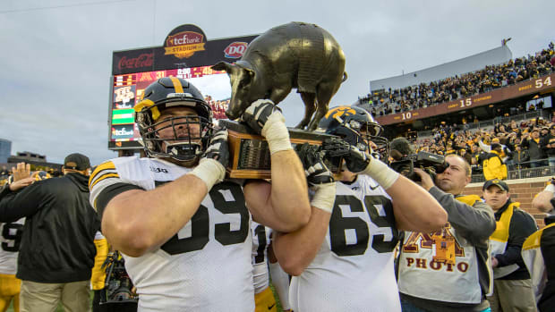 Iowa offensive lineman Ross Reynolds (59) and offensive lineman Keegan Render (69) lift the Floyd of Rosedale trophy at TCF Bank Stadium after last year's win over Minnesota.