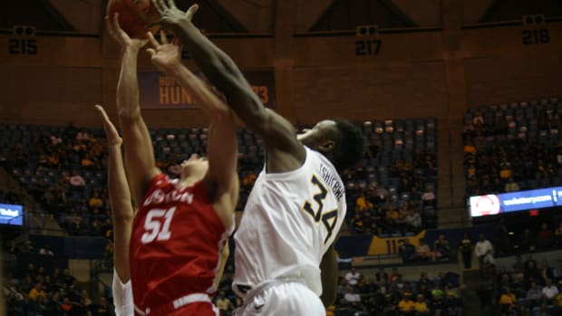 West Virginia forward Oscar Tshiebwe with a block on Bostons Max Mahoney inside the WVU Coliseum on Friday night in the second round of the Cancun Challenge.