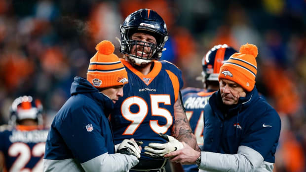 Denver Broncos defensive end Derek Wolfe (95) is helped off the field in the fourth quarter against the Los Angeles Chargers at Empower Field at Mile High.