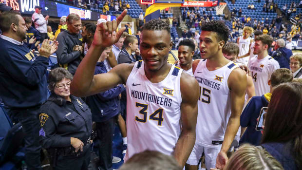 West Virginia Mountaineers forward Oscar Tshiebwe (34) and forward Jalen Bridges (15) celebrates with fans after defeating the Nicholls State Colonels at WVU Coliseum.