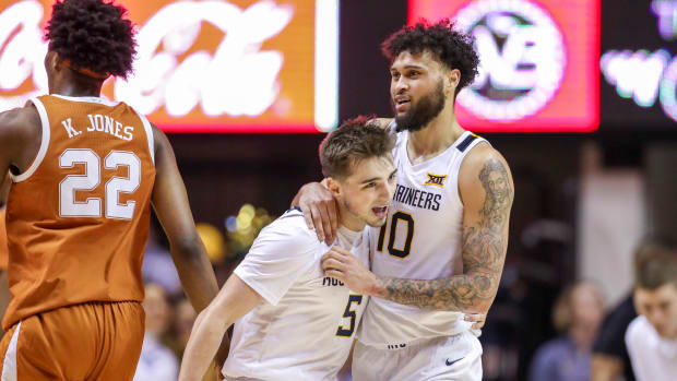 West Virginia Mountaineers guard Jordan McCabe (5) celebrates with West Virginia Mountaineers guard Jermaine Haley (10) after a play during the first half against the Texas Longhorns at WVU Coliseum.