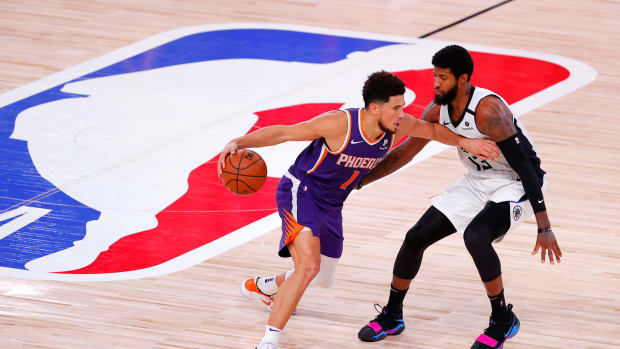 Aug 4, 2020; Lake Buena Vista, USA; Paul George #13 of the LA Clippers defends Devin Booker #1 of the Phoenix Suns at The Arena at ESPN Wide World Of Sports Complex on August 04, 2020 in Lake Buena Vista, Florida.