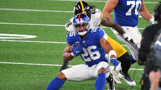 Sep 14, 2020; East Rutherford, New Jersey, USA; New York Giants running back Saquon Barkley (26) runs the ball in front of Pittsburgh Steelers outside linebacker Bud Dupree (48) during the first quarter at MetLife Stadium.