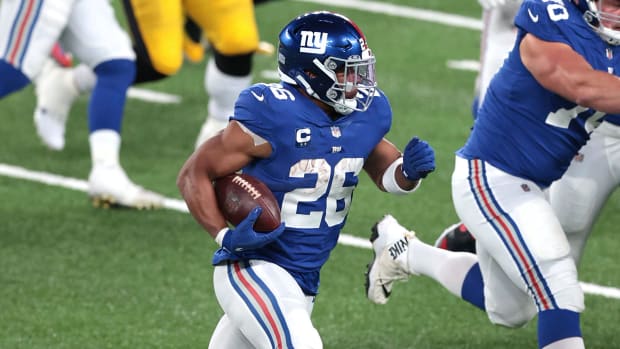 New York Giants running back Saquon Barkley (26) carries the ball against the Pittsburgh Steelers as offensive guard Kevin Zeitler (70) blocks during the second half at MetLife Stadium.