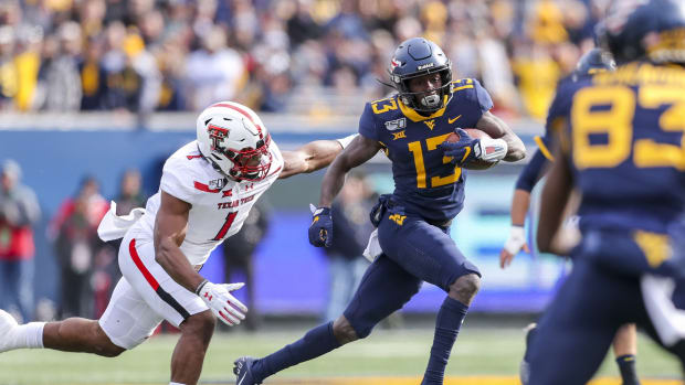 West Virginia Mountaineers wide receiver Sam James (13) runs after a catch against Texas Tech Red Raiders linebacker Jordyn Brooks (1) during the first quarter at Mountaineer Field at Milan Puskar Stadium.