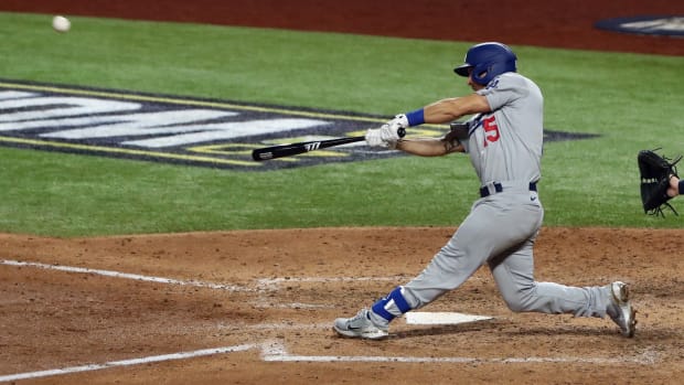 Oct 23, 2020; Arlington, Texas, USA; Los Angeles Dodgers catcher Austin Barnes (15) hits a home run against the Tampa Bay Rays during the sixth inning of game three of the 2020 World Series at Globe Life Field. Mandatory Credit: Kevin Jairaj-USA TODAY Sports
