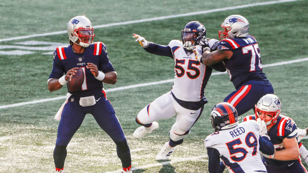 New England Patriots quarterback Cam Newton (1) looks downfield as offensive tackle Isaiah Wynn (76) tries to keep Denver Broncos linebacker Bradley Chubb (55) away during the second half at Gillette Stadium.