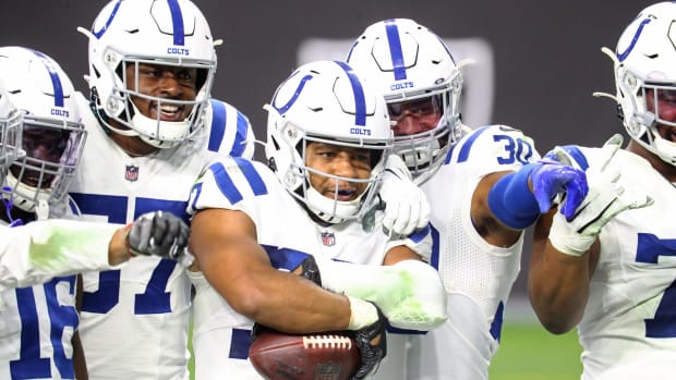 Indianapolis Colts safety Khari Willis (with ball) poses with teammates after a pick-six at Las Vegas.