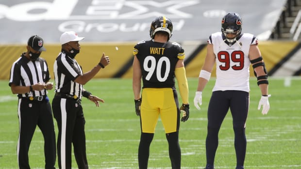 Sep 27, 2020; Pittsburgh, Pennsylvania, USA; NFL referee Shawn Smith (14) flips the coin as brothers Pittsburgh Steelers outside linebacker T.J. Watt (90) and Houston Texans defensive end J.J. Watt (99) take part before their game against at Heinz Field. The Steelers won 28-21. Mandatory Credit: Charles LeClaire-USA TODAY Sports