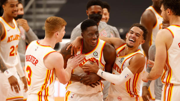 Atlanta Hawks guard Tony Snell (19) is congratulated by guard Kevin Huerter (3) and guard Trae Young (11) teammates as he makes the game winning three point basket to beat the Toronto Raptors on March 11, 2021.