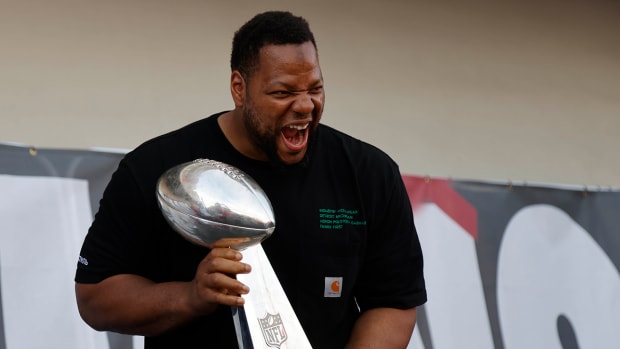 Ndamukong Suh celebrates with the Lombardi Trophy at Super Bowl boat parade.