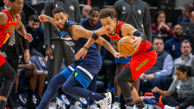 Allen Crabbe of the Timberwolves fights for the ball vs. Trae Young of Hawks.
