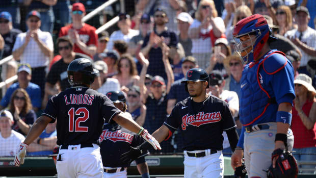 Cleveland Indians shortstop Francisco Lindor (12) slaps hands with Cleveland Indians second baseman Cesar Hernandez (7) after hitting a solo home run against the Chicago Cubs during the first inning of a spring training game at Goodyear Ballpark.
