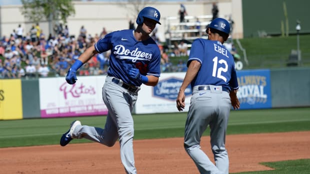 Mar 8, 2020; Surprise, Arizona, USA; Los Angeles Dodgers outfielder Cody Thomas (95) slaps hands with third base coach Dino Ebel (12) after hitting a two run home run against the Texas Rangers during the second inning of a spring training game at Surprise Stadium. Mandatory Credit: Joe Camporeale-USA TODAY Sports