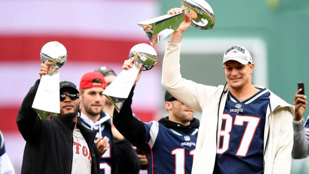 Retired New England Patriots player Rob Gronkowski (right) holds up a Lombardi Trophy before a game between the Boston Red Sox and the Toronto Blue Jays at Fenway Park