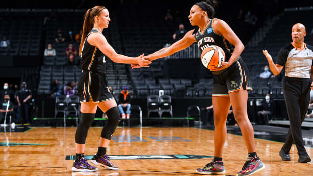 Sabrina Ionescu low-fiving Betnijah Laney