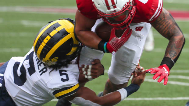 Wisconsin Badgers running back Chez Mellusi (6) runs the ball as Michigan Wolverines defensive back DJ Turner (5) tackles him during their game Saturday, Oct. 2, 2021, at Camp Randall Stadium in Madison, Wis. Ebony Cox / Milwaukee Journal Sentinel