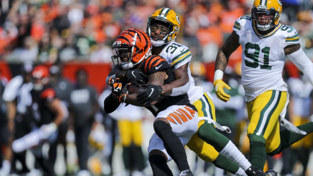 Oct 10, 2021;  Cincinnati, Ohio, USA;  Cincinnati Bengals wide receiver Ja'Marr Chase (1) runs with the ball against Green Bay Packers safety Adrian Amos (31) in the first half at Paul Brown Stadium.  Mandatory Credit: Katie Stratman-USA TODAY Sports