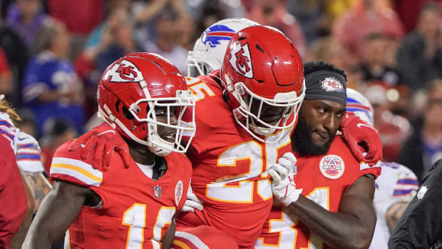 Oct 10, 2021; Kansas City, Missouri, USA; Kansas City Chiefs running back Clyde Edwards-Helaire (25) is carried off the field by wide receiver Tyreek Hill (10) and running back Darrel Williams (31) after an injury against the Buffalo Bills during the second half at GEHA Field at Arrowhead Stadium. Mandatory Credit: Denny Medley-USA TODAY Sports