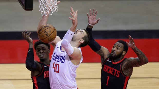 Apr 23, 2021; Houston, Texas, USA; Ivica Zubac #40 of the LA Clippers loses control of the ball as he shoots between John Wall #1 and Jae'Sean Tate #8 of the Houston Rockets during the first quarter at Toyota Center. Mandatory Credit: Carmen Mandato/POOL PHOTOS-USA TODAY Sports