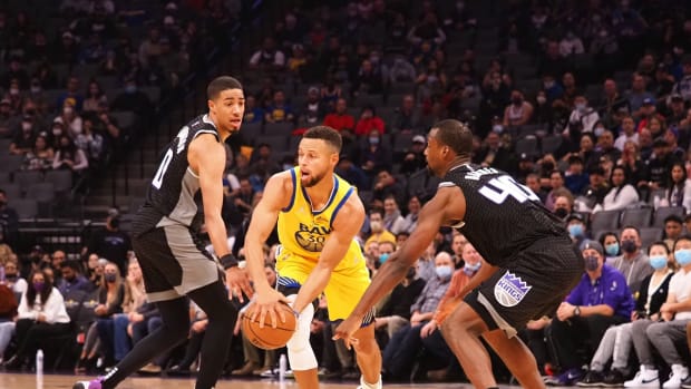 Oct 24, 2021; Sacramento, California, USA; Golden State Warriors guard Stephen Curry (30) passes the ball between Sacramento Kings guard Tyrese Haliburton (0) and forward Harrison Barnes (40) during the first quarter at Golden 1 Center. Mandatory Credit: Kelley L Cox-USA TODAY Sports
