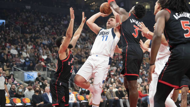 Oct 23, 2021; Toronto, Ontario, CAN; Dallas Mavericks guard Luka Doncic (77) drives to the basket as Toronto Raptors guard Fred VanVleet (23) and Toronto Raptors forward OG Anunoby (3) try to defend during the first quarter at Scotiabank Arena. Mandatory Credit: Nick Turchiaro-USA TODAY Sports