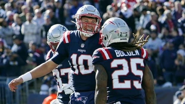New England running back Brandon Bolden celebrates with quarterback Mac Jones after his touchdown during the first half of Sunday's 54-13 win over the Jets at Gillette Stadium.