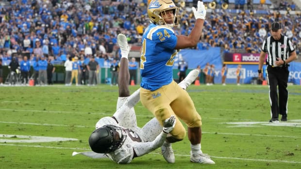 Oct 23, 2021; Pasadena, California, USA; UCLA Bruins running back Zach Charbonnet (24) is defended by cornerback Dontae Manning (8) in the second half at Rose Bowl. Oregon defeated UCLA 34-31. Mandatory Credit: Kirby Lee-USA TODAY Sports
