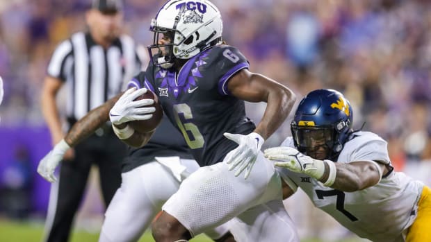 Oct 23, 2021; Fort Worth, Texas, USA; TCU Horned Frogs running back Zach Evans (6) runs the ball while being tackled by West Virginia Mountaineers linebacker Josh Chandler-Semedo (7) during the third quarter at Amon G. Carter Stadium.