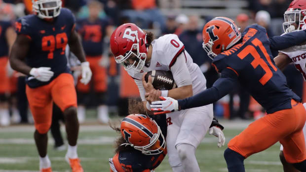 Oct 30, 2021; Champaign, Illinois, USA; Illinois Fighting Illini defensive back Sydney Brown (30) and teammate Devon Witherspoon (31) team up to tackle Rutgers Scarlet Knights quarterback Noah Vedral (0) in the second half at Memorial Stadium. Mandatory Credit: Ron Johnson-USA TODAY Sports