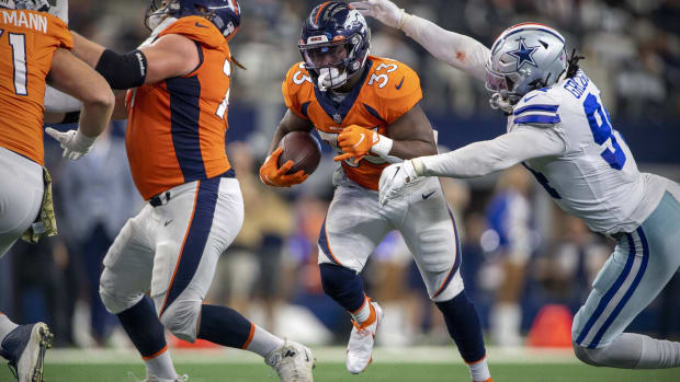 Denver Broncos running back Javonte Williams (33) tries to elude Dallas Cowboys defensive end Randy Gregory (94) during the second half at AT&T Stadium.