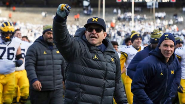 Michigan coach Jim Harbaugh pumps a fist after beating Penn State