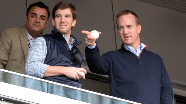 Eli and Peyton Manning at a baseball game.