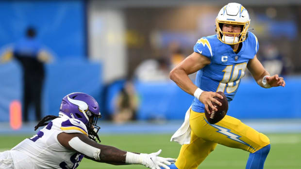 Nov 14, 2021; Inglewood, California, USA; Los Angeles Chargers quarterback Justin Herbert (10) gets away from Minnesota Vikings defensive tackle Armon Watts (96) as he looks for an open receiver in the second half at SoFi Stadium. Mandatory Credit: Jayne Kamin-Oncea-USA TODAY Sports