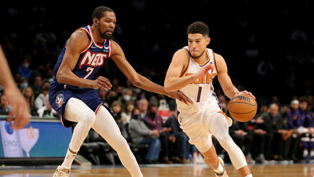 Phoenix Suns guard Devin Booker (1) drives with the ball around Brooklyn Nets forward Kevin Durant (7) during the first quarter at Barclays Center