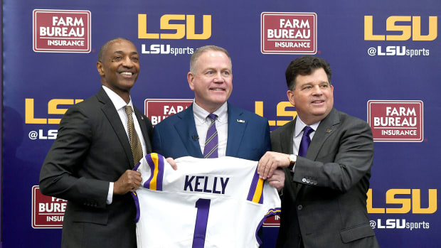 Brian Kelly poses with LSU president William Tate IV (left) and AD Scott Woodward (right)