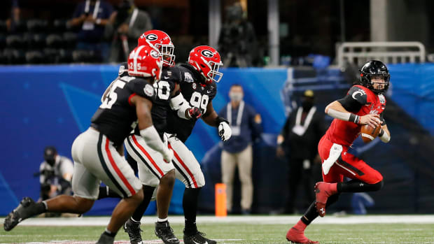 Cincinnati Bearcats quarterback Desmond Ridder (9) scrambles out of the pocket as he's chased in the fourth quarter of the Chick-fil-a Peach Bowl at Mercedes-Benz Stadium in Atlanta on Friday, Jan. 1, 2021. A last-minute field goal sealed a 24-21 win for the Bulldogs, leaving the Bearcats 9-1 on the season. Cincinnati Bearcats Vs Georgia Bulldogs Peach Bowl