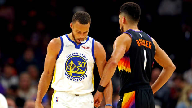 Nov 30, 2021; Phoenix, Arizona, USA; Golden State Warriors guard Stephen Curry (30) reacts with Phoenix Suns guard Devin Booker (1) during the first quarter at Footprint Center. Mandatory Credit: Mark J. Rebilas-USA TODAY Sports