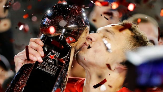 Cincinnati Bearcats quarterback Desmond Ridder (9) kisses the American Athletic Conference Championship trophy during a ceremony after the American Athletic Conference Championship football game between the Cincinnati Bearcats and the Houston Cougars at Nippert Stadium in Cincinnati on Saturday, Dec. 4, 2021. The Bearcats remained unbeaten as they won the AAC Championship with a 35-20. Houston Cougars At Cincinnati Bearcats American Athletic Conference Championship