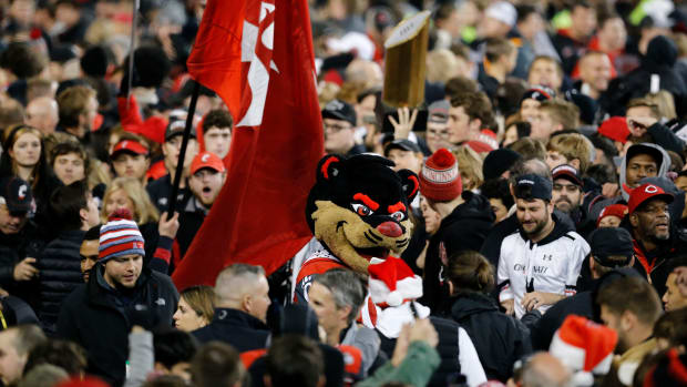 Fan revel on the field after the American Athletic Conference Championship football game between the Cincinnati Bearcats and the Houston Cougars at Nippert Stadium in Cincinnati on Saturday, Dec. 4, 2021. The Bearcats remained unbeaten as they won the AAC Championship with a 35-20. Houston Cougars At Cincinnati Bearcats American Athletic Conference Championship