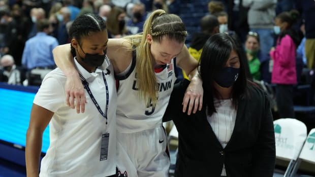 Paige Bueckers is helped off the floor.