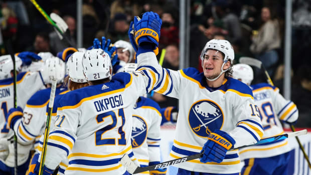 Dec 16, 2021; Saint Paul, Minnesota, USA; Buffalo Sabres right wing Kyle Okposo (21) and center John Hayden (15) celebrate their victory against the Minnesota Wild at Xcel Energy Center. Mandatory Credit: David Berding-USA TODAY Sports