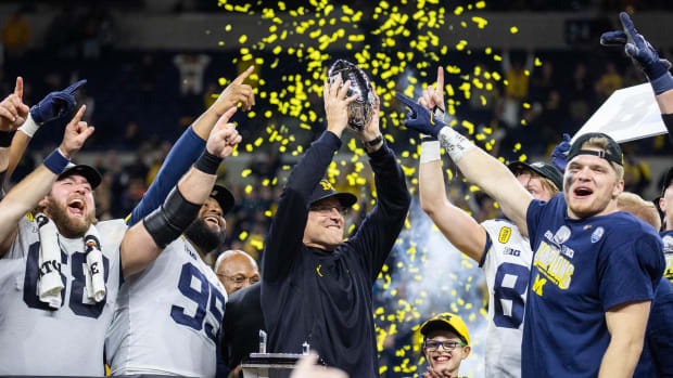 Dec 4, 2021; Indianapolis, IN, USA; Michigan Wolverines head coach Jim Harbaugh lifts the Big Ten Championship Trophy with his team after the game against the Iowa Hawkeyes at Lucas Oil Stadium.