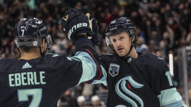 Dec 18, 2021; Seattle, Washington, USA; Seattle Kraken left wing Jared McCann (16) celebrates with right wing Jordan Eberle (7) after scoring a goal during the first period at Climate Pledge Arena. Mandatory Credit: Stephen Brashear-USA TODAY Sports