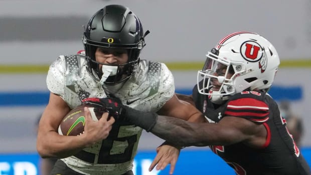 Dec 3, 2021; Las Vegas, NV, USA; Oregon Ducks running back Travis Dye (26) is defended by Utah Utes cornerback Malone Mataele (15) inthe first half during the 2021 Pac-12 Championship Game at Allegiant Stadium. Mandatory Credit: Kirby Lee-USA TODAY Sports