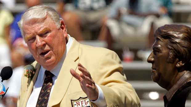 FILE - Former Oakland Raiders coach John Madden gestures toward a bust of himself during his enshrinement into the Pro Football Hall of Fame in Canton, Ohio, Aug. 5, 2006.