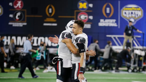 Cincinnati Bearcats wide receiver Blue Smith (83), left, and Bearcats quarterback Desmond Ridder hug after loosing to University of Alabama 27-6 in the College Football Playoff Semifinal at the 86th Cotton Bowl Classic Friday December 31, 2021 at AT & T Stadium in Arlington, Texas. Uc Bama9